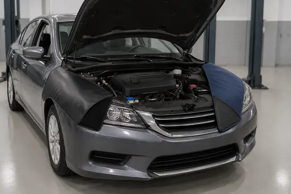 Vinyl and woven automotive fender covers protecting both front fenders of a car