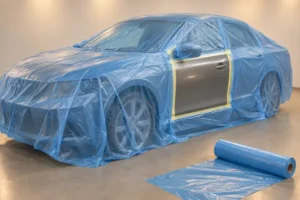 Automotive paint masking film covering a car around an exposed repair panel during a controlled heated drying-cycle illustration