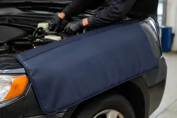 Reusable padded fender cover protecting a vehicle during engine service